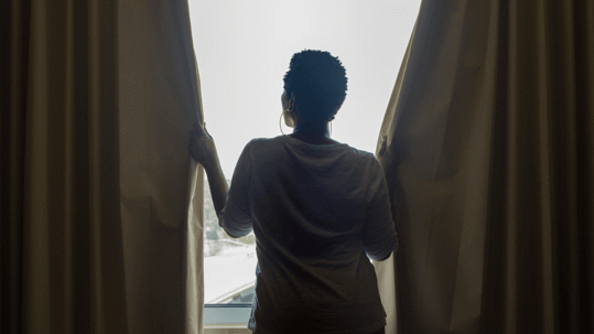 Woman closing curtains