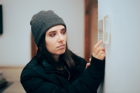 woman cranking up the thermostat
