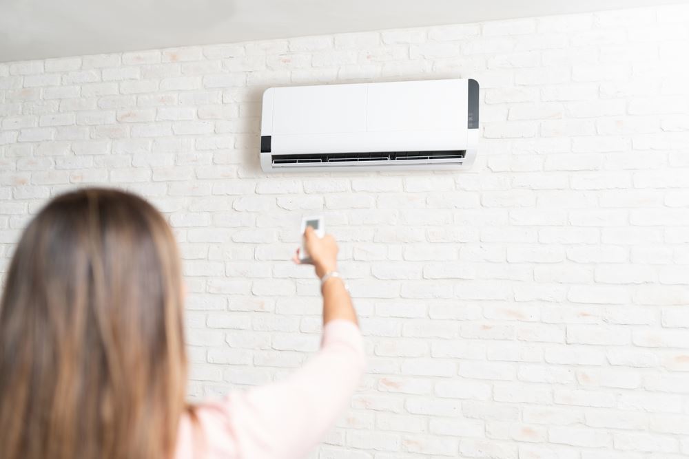 Homeowner switching on ductless mini-split AC in Memphis home